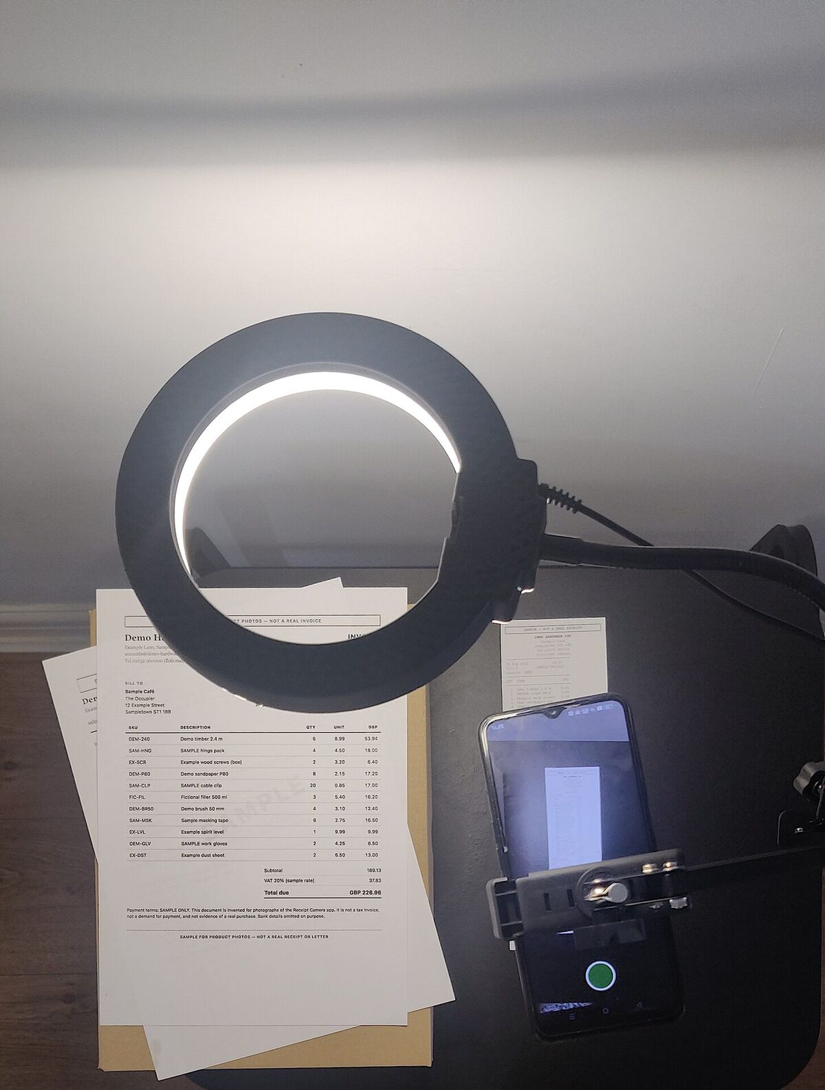 Looking down at the ring light, phone, and papers on a box